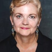 short haired blond woman looks at camera for business head shot photo